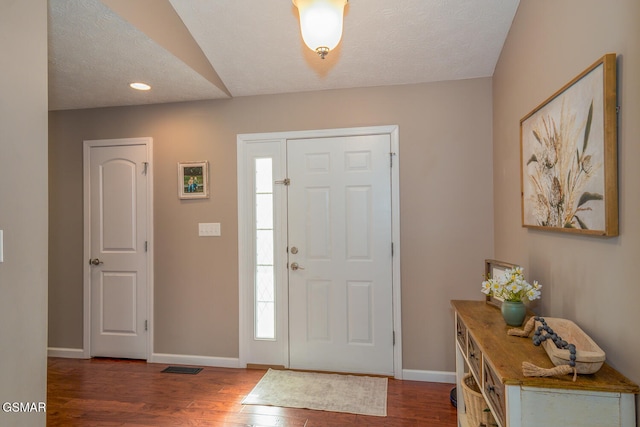 entryway with a textured ceiling and dark wood-type flooring