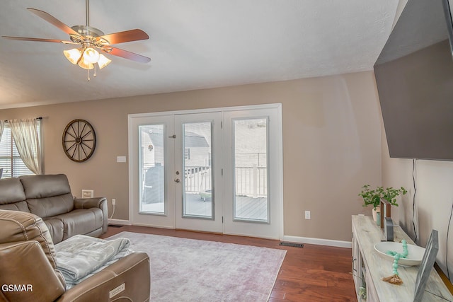 living room with ceiling fan, french doors, and dark hardwood / wood-style flooring