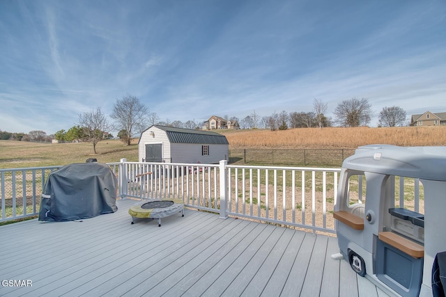 wooden deck with a lawn, a grill, and a storage shed