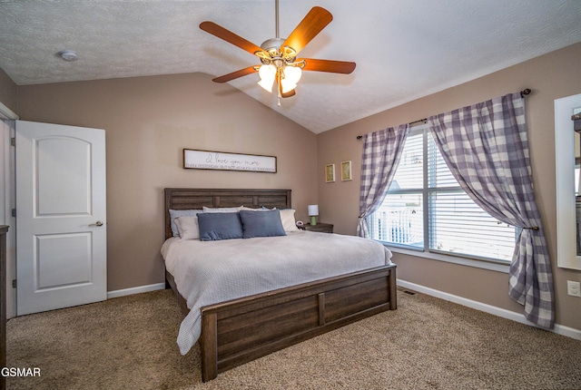 bedroom with vaulted ceiling, ceiling fan, carpet floors, and a textured ceiling