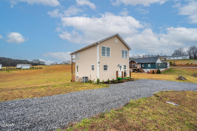 view of side of home with a yard and central AC unit