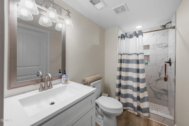 bathroom with hardwood / wood-style flooring, vanity, a shower with curtain, and toilet