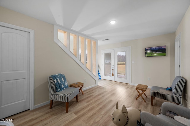 living area featuring light wood-type flooring and french doors