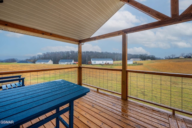 wooden deck with a yard and a rural view