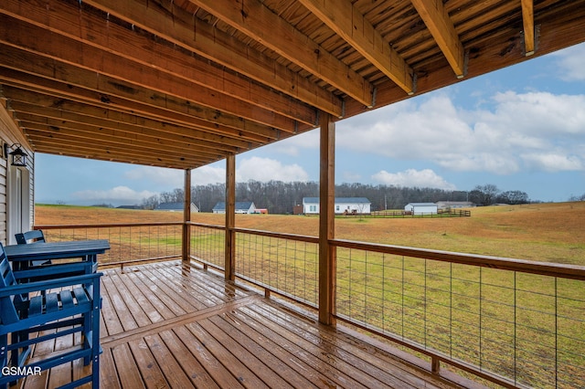 wooden deck with a rural view and a yard