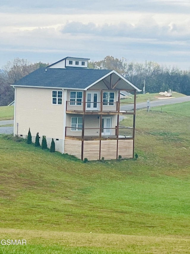 rear view of property featuring a lawn