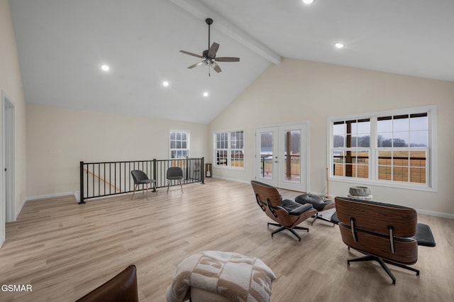 living area featuring beamed ceiling, light wood-type flooring, french doors, and a wealth of natural light