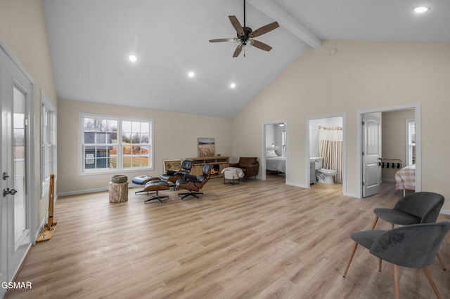 sitting room featuring light wood-type flooring, high vaulted ceiling, beamed ceiling, and ceiling fan