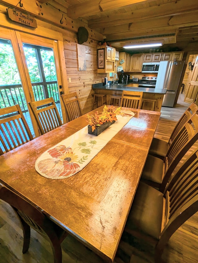 dining space featuring wooden walls and sink