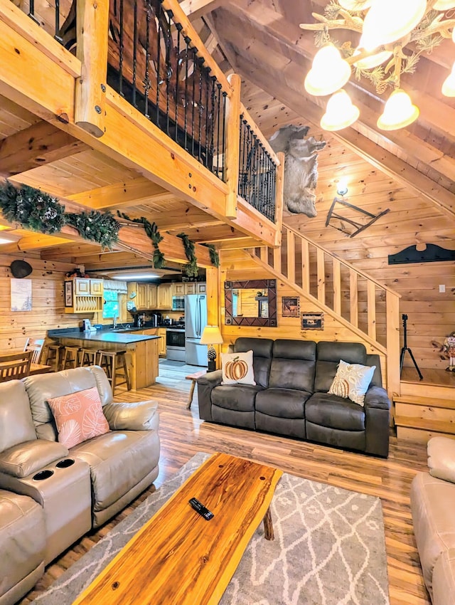 living room featuring wood ceiling, wooden walls, beam ceiling, hardwood / wood-style flooring, and a high ceiling