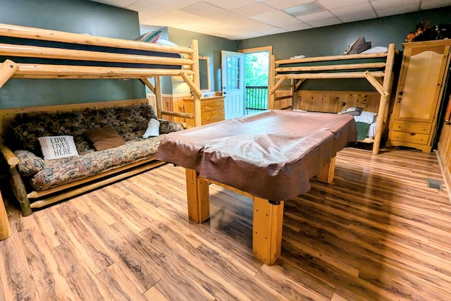 bedroom with hardwood / wood-style floors, a paneled ceiling, and pool table