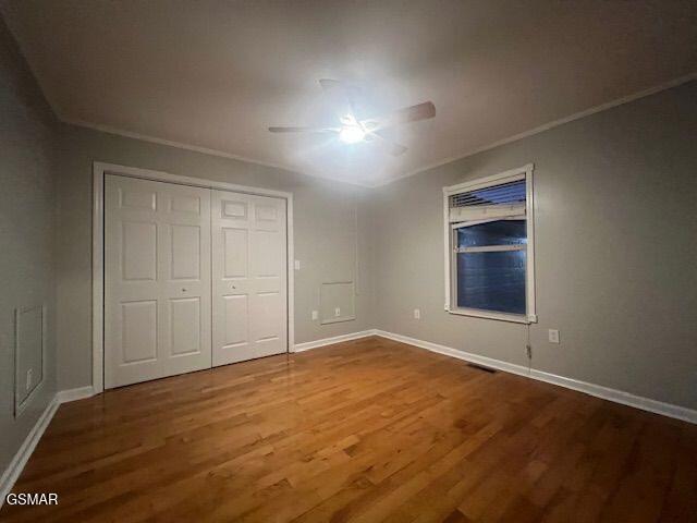 734 Southview Cir, Kodak, TN 37764 - unfurnished bedroom with wood finished floors, crown molding, baseboards, a closet, and a ceiling fan