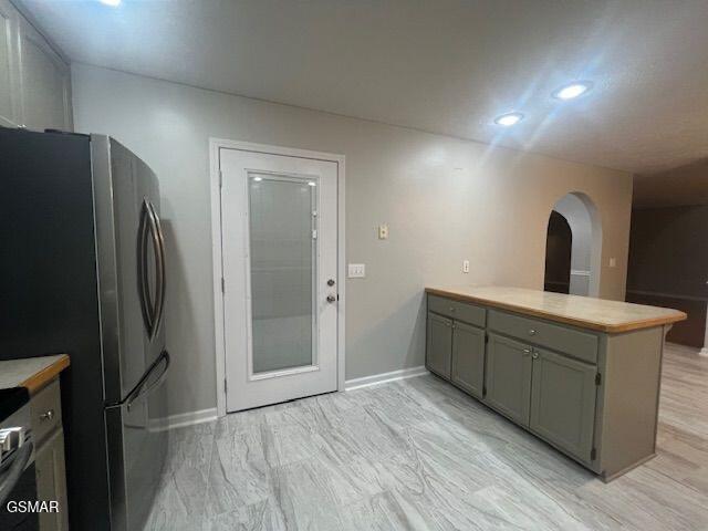 734 Southview Cir, Kodak, TN 37764 - kitchen featuring freestanding refrigerator, a peninsula, arched walkways, light countertops, and baseboards