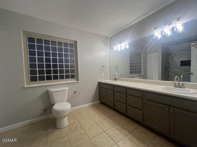 734 Southview Cir, Kodak, TN 37764 - full bathroom with tile patterned floors, toilet, tiled shower, baseboards, and double vanity