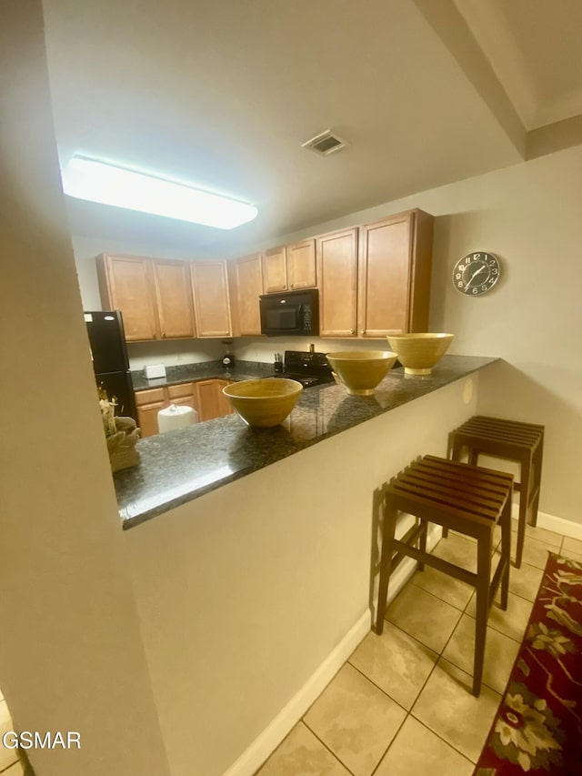 124 Plaza Dr Unit 3107, Pigeon Forge, TN 37863 - kitchen featuring black appliances, light brown cabinets, a peninsula, and light tile patterned floors