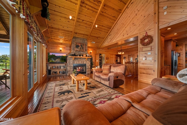 3995 Island View Way, Sevierville, TN 37876 - living room with hardwood / wood-style flooring, wood walls, a stone fireplace, high vaulted ceiling, and a chandelier