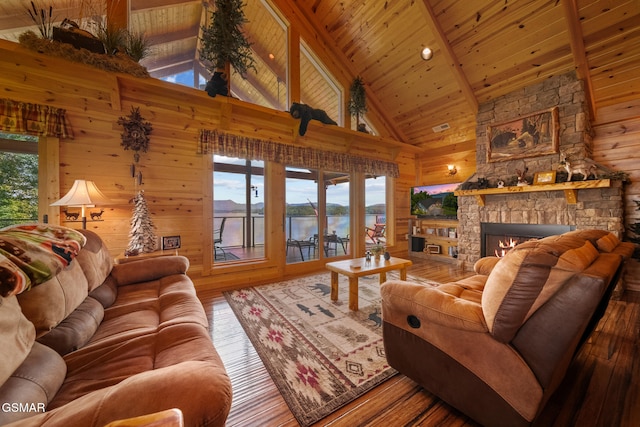 3995 Island View Way, Sevierville, TN 37876 - living room featuring wooden walls, wood-type flooring, high vaulted ceiling, a wooden ceiling with exposed beams, and a stone fireplace