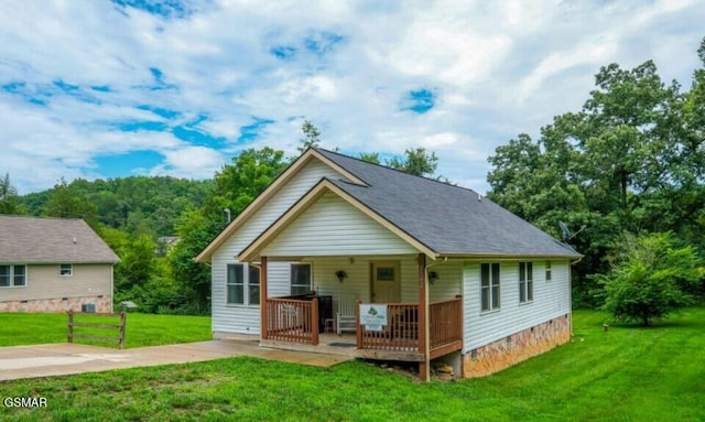 rear view of property with a yard and covered porch