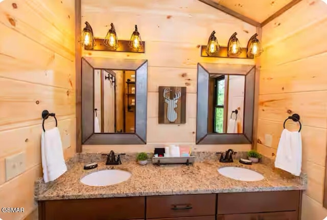 bathroom featuring double vanity, a sink, and wood walls