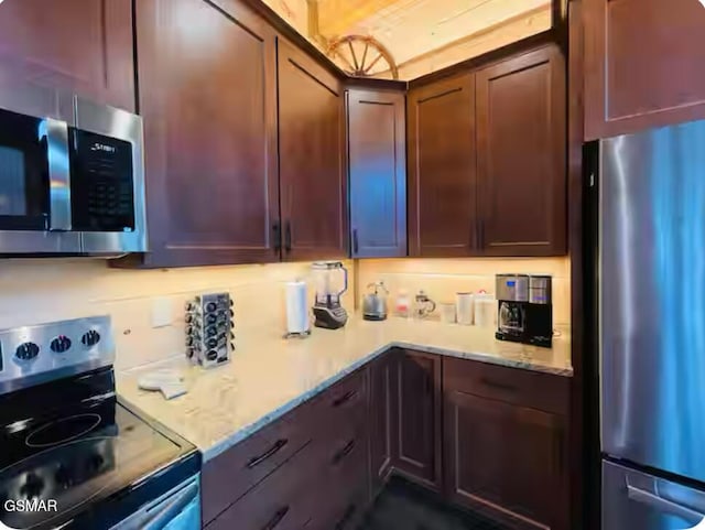 kitchen featuring light stone counters and stainless steel appliances