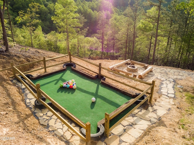 exterior space with a fire pit and a wooded view