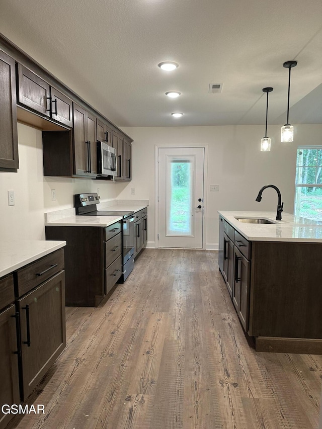 kitchen with stainless steel appliances, light countertops, a sink, and visible vents