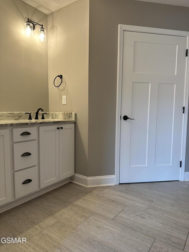 bathroom featuring baseboards and vanity