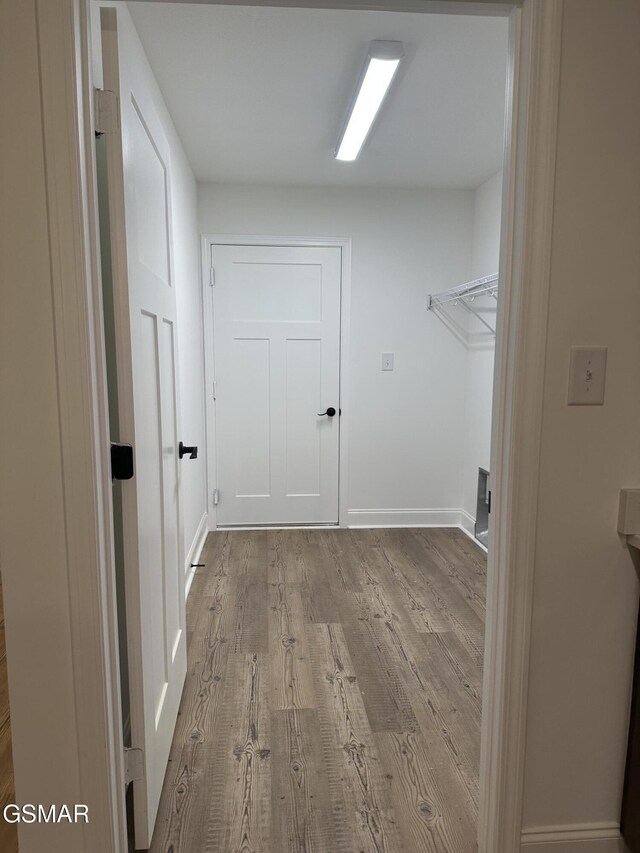 laundry room featuring light wood-style flooring and baseboards