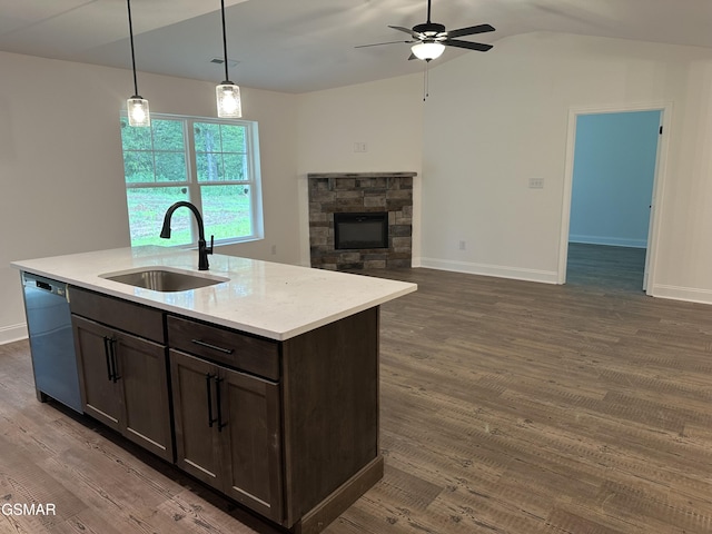 kitchen featuring dark brown cabinetry, black dishwasher, an island with sink, hanging light fixtures, and a sink