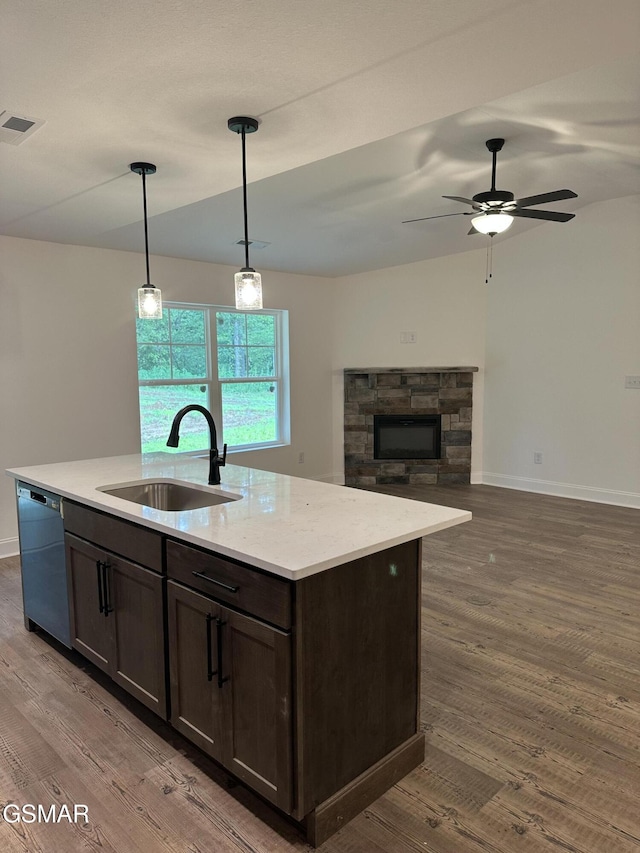 kitchen featuring dark brown cabinetry, a sink, visible vents, hanging light fixtures, and dishwasher