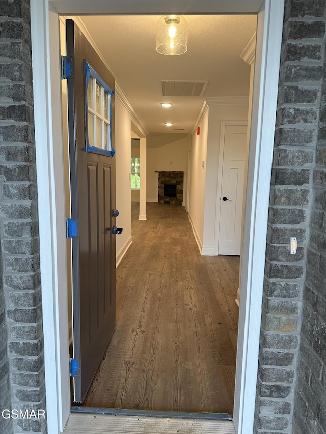 hall with baseboards, visible vents, crown molding, and wood finished floors