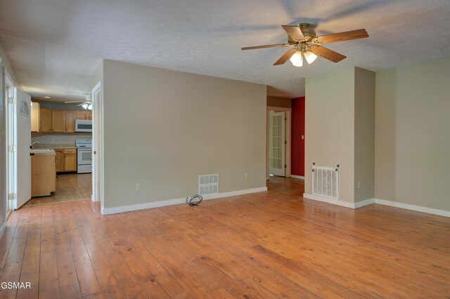 1940 Big Chiefs Skyview Dr, Sevierville, TN 37876 - unfurnished living room featuring light wood-type flooring, ceiling fan, baseboards, and visible vents