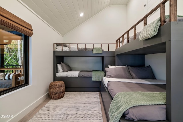 bedroom featuring crown molding, wood ceiling, wood finished floors, high vaulted ceiling, and baseboards