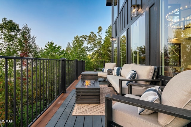 wooden deck featuring an outdoor living space with a fire pit