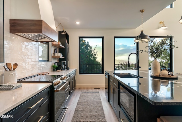 kitchen with black microwave, dark cabinets, island range hood, a sink, and stainless steel electric stove