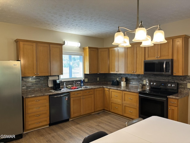147 Padgett Mill Rd, Cosby, TN 37722 - kitchen featuring stainless steel appliances, a sink, dark countertops, decorative backsplash, and wood finished floors