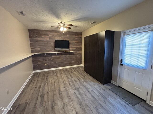 147 Padgett Mill Rd, Cosby, TN 37722 - unfurnished living room with wooden walls, wood finished floors, visible vents, and ceiling fan