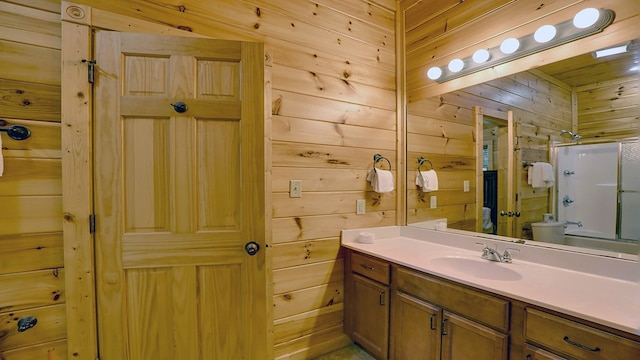 full bathroom featuring vanity, bathing tub / shower combination, toilet, and wood walls