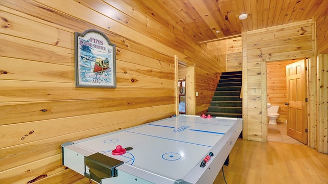 game room featuring wood walls, wood ceiling, and light wood-type flooring