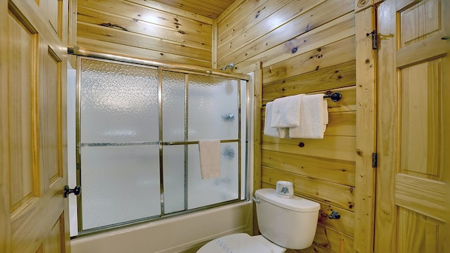 bathroom featuring wood walls, wooden ceiling, enclosed tub / shower combo, and toilet