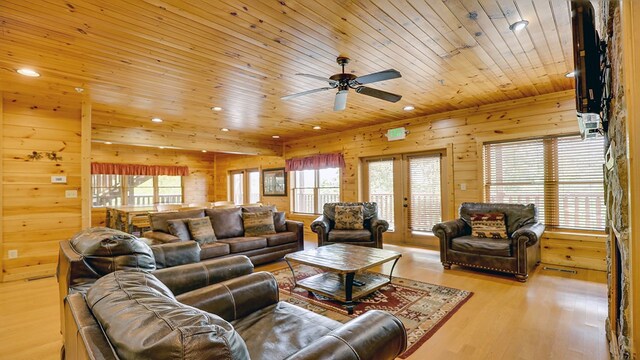 living room with wood walls, light hardwood / wood-style flooring, a healthy amount of sunlight, and wood ceiling