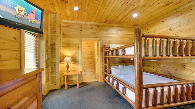 bedroom featuring carpet, wooden walls, and wood ceiling