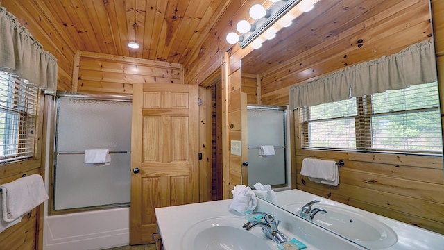 bathroom featuring shower / bath combination with glass door, vanity, wood ceiling, and wood walls