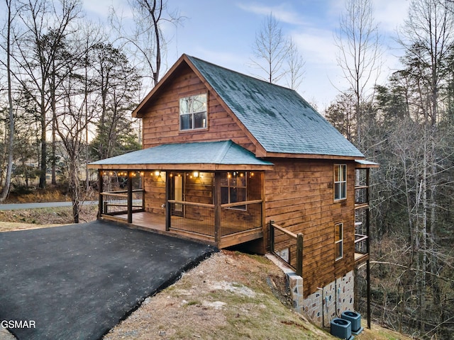 view of front of house with central AC, a porch, a shingled roof, and aphalt driveway