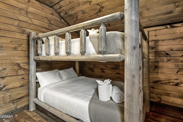 bedroom with lofted ceiling, wooden ceiling, wood walls, and wood finished floors