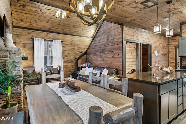 dining space with vaulted ceiling, wood ceiling, wood walls, and wood finished floors