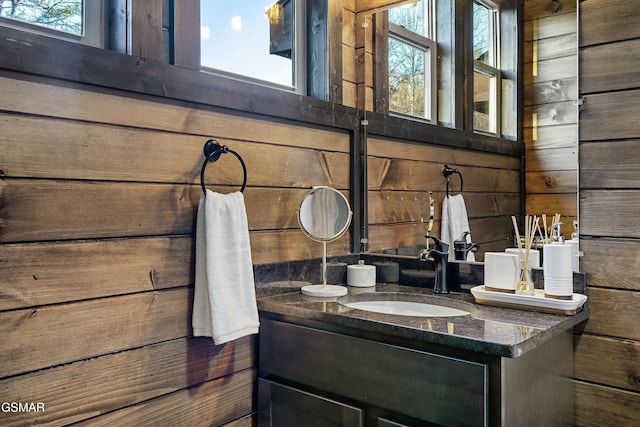 bathroom featuring wood walls and vanity