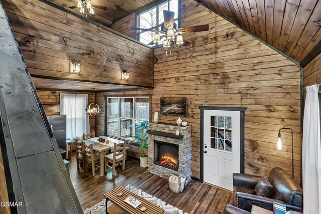 unfurnished living room with a ceiling fan, wood ceiling, wooden walls, and wood finished floors