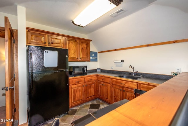 kitchen with sink, black appliances, and lofted ceiling