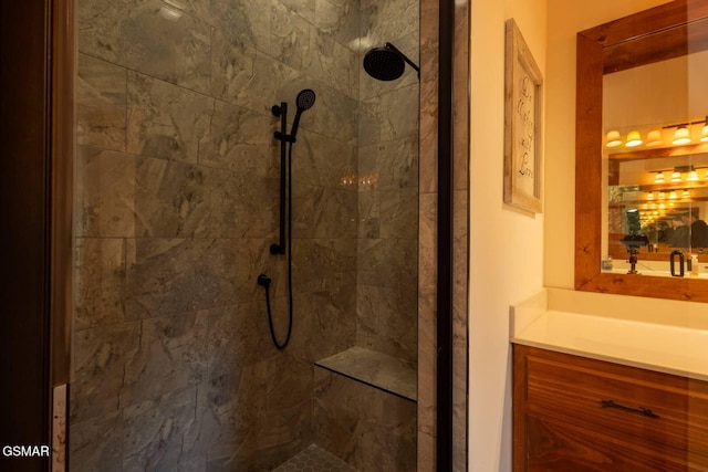 bathroom featuring tiled shower and vanity